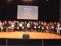 Emekli öğretmen hizmet şeref belgesini kucağında çocuğuyla aldı